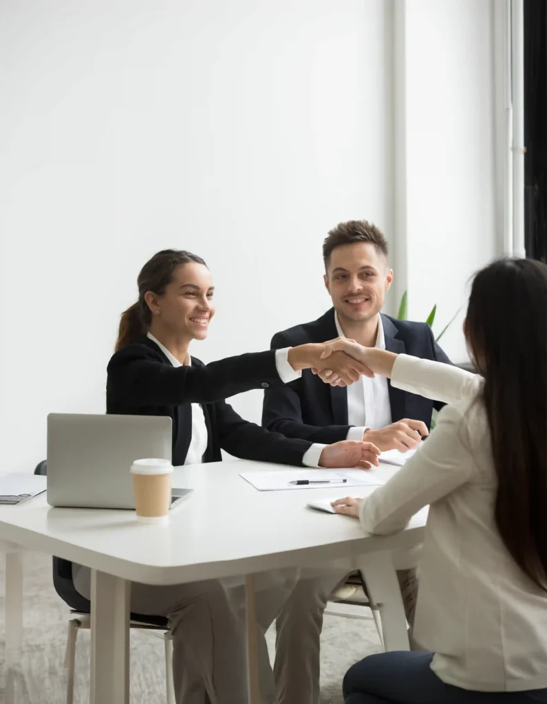 IT staff augmentation meeting: diverse team shaking hands during a successful collaboration, highlighting flexible IT staffing solutions.