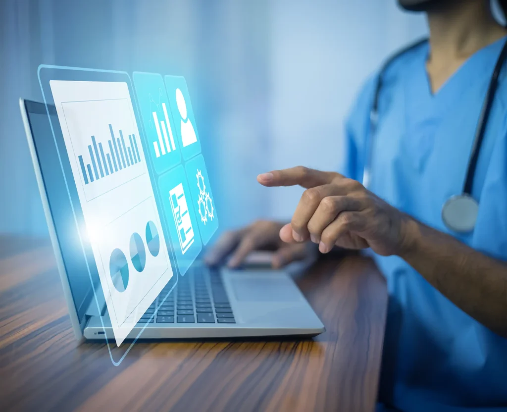 Healthcare professional in blue scrubs interacts with holographic data and charts on a laptop screen.